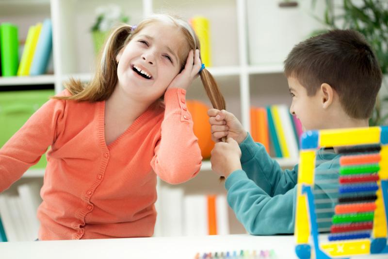 a boy pulling a girl's pigtail